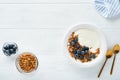 Yogurt. Greek Yogurt with granola and fresh blueberries in white bowl over old white wood background. Morning breakfast concept. H Royalty Free Stock Photo