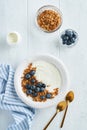 Yogurt. Greek Yogurt with granola and fresh blueberries in white bowl over old white wood background. Morning breakfast concept. Royalty Free Stock Photo