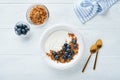 Yogurt. Greek Yogurt with granola and fresh blueberries in white bowl over old white wood background. Morning breakfast concept. Royalty Free Stock Photo