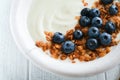 Yogurt. Greek Yogurt with granola and fresh blueberries in white bowl over old white wood background. Morning breakfast concept. H Royalty Free Stock Photo