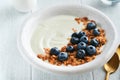 Yogurt. Greek Yogurt with granola and fresh blueberries in white bowl over old white wood background. Morning breakfast concept. Royalty Free Stock Photo