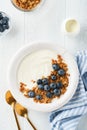 Yogurt. Greek Yogurt with granola and fresh blueberries in white bowl over old white wood background. Morning breakfast concept. Royalty Free Stock Photo