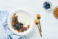 Yogurt. Greek Yogurt with granola and fresh blueberries in white bowl over old white wood background. Morning breakfast concept. Royalty Free Stock Photo