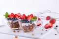 Yogurt with muesli and berries in small glass cups. Breakfast table