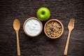 Yogurt with muesli for breakfast in the morning, loss weight and green apple diet slimming for women, old wood background.