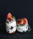 Yogurt and oat granola with grapes, pomegranate, grapefruit in tall glass jar