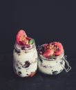 Yogurt and oat granola with grapes, pomegranate, grapefruit in tall glass jar