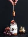 Yogurt and oat granola with grapes, pomegranate, grapefruit in tall glass jar