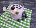 Yogurt oatmeal cherry, dessert blueberry glass on a black wooden background