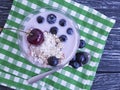 Yogurt oatmeal jar cherry, dessert homemade blueberry glass on a black wooden background