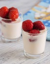 Yogurt with strawberries in a glass on wooden table with blue napkin Royalty Free Stock Photo