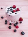 Yogurt, strawberry, raspberry, glass blueberries homemade a pink wooden background,
