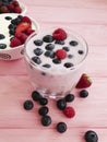 Yogurt, strawberry, raspberry, glass refreshment blueberries homemade a pink wooden background,