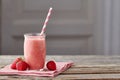 Yogurt and strawberry smoothie in jar with drinking straw on wooden table Royalty Free Stock Photo