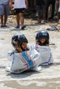 Children wearing a helmet having a sack race Royalty Free Stock Photo