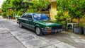 Green Peugeot 505 sedan parked on the front of a house