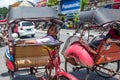 Yogyakarta, Indonesia - Elderly Rickshaw driver is looking for customers on Malionoro Road in Yogyakarta.