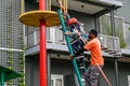 Yogyakarta, Indonesia - March 03, 2022: A game safety officer helps a girl climb a ladder at Suraloka Zoo, Yogyakarta