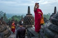 Yogyakarta, Indonesia - March 17, 2018: Monk makes photos at Borobudur temple sunrise in Yogyakarta