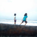 Yogyakarta, Indonesia - May 2022: Two brothers and sisters are playing on the beach. Royalty Free Stock Photo