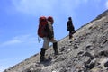 Two climbers take time off on a stretch of sand and rock on their way to the top of Mount Merapi