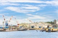 United States Navy valiant-class tug Puyallup YT-806 in front of tower cranes in Yokosuka naval port.