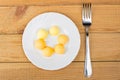 Yolk of boiled eggs in white plate and fork