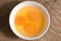 Yolk in a ceramic dish on a wooden background, top view Royalty Free Stock Photo