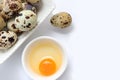 Yolk quail egg without shell and raw quail eggs in bowl on white background.
