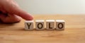 Yolo concept. Word yolo on wooden cube with finger to shows letter y. You Only Live Once phrase Royalty Free Stock Photo