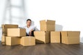 A yong asian man sitting on floor with boxes