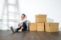 A yong asian man sitting on floor with boxes