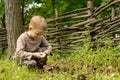 Yong boy lighting a fire alongside a rustic fence Royalty Free Stock Photo