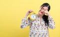 Yong woman holding a clock showing 6AM Royalty Free Stock Photo