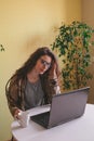 Woman wearing glasses and casual clothes touch her head while working on computer at home, stress and fatigue concept