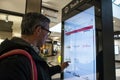 Adult man using an interactive touch display information board in a shopping mall centre