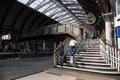 Couple of travellers climbing staircase with luggage in an old Victorian Railway Station