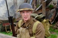 Enactor dressed as British world war two soldier resting in trench.