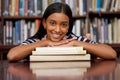 You absolutely have to know, is the location of the library. a young woman resting on a pile of books in a college