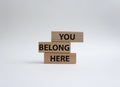 You belong here symbol. Wooden blocks with words You belong here. Beautiful white background. Business and You belong here