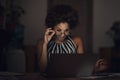 You better believe it. a young businesswoman using a laptop and looking surprised during a late night at work.