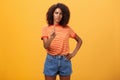 You better not. Dissatisfied bossy serious-looking african american curly-haired female head manager in t-shirt frowning