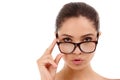 You better watch out...a beautiful woman standing in a studio while wearing glasses.