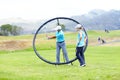 You bring it back and round to here ...Image of a male coach instructing his female student using a ring to adjust and