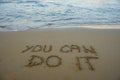 You can do it. Motivational inspirational message concept written on the sand of beach.