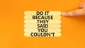You can do it symbol. Concept words Do it because they said you could not on wooden stick. Beautiful orange background.