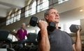 You can lift at any age. a senior man working out with weights at the gym. Royalty Free Stock Photo