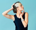 You can never be overdressed. Studio shot of an elegantly dressed young woman posing against a blue background.