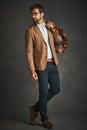 You can never be overdressed. Studio shot of a handsome young man posing against a gray background.