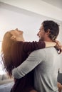 You can never have enough love and laughter. an affectionate young couple hugging in the kitchen at home.